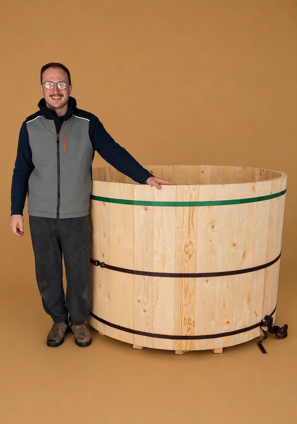 Wood-fired soaking tub with natural wood exterior, entry steps, and firewood nearby
